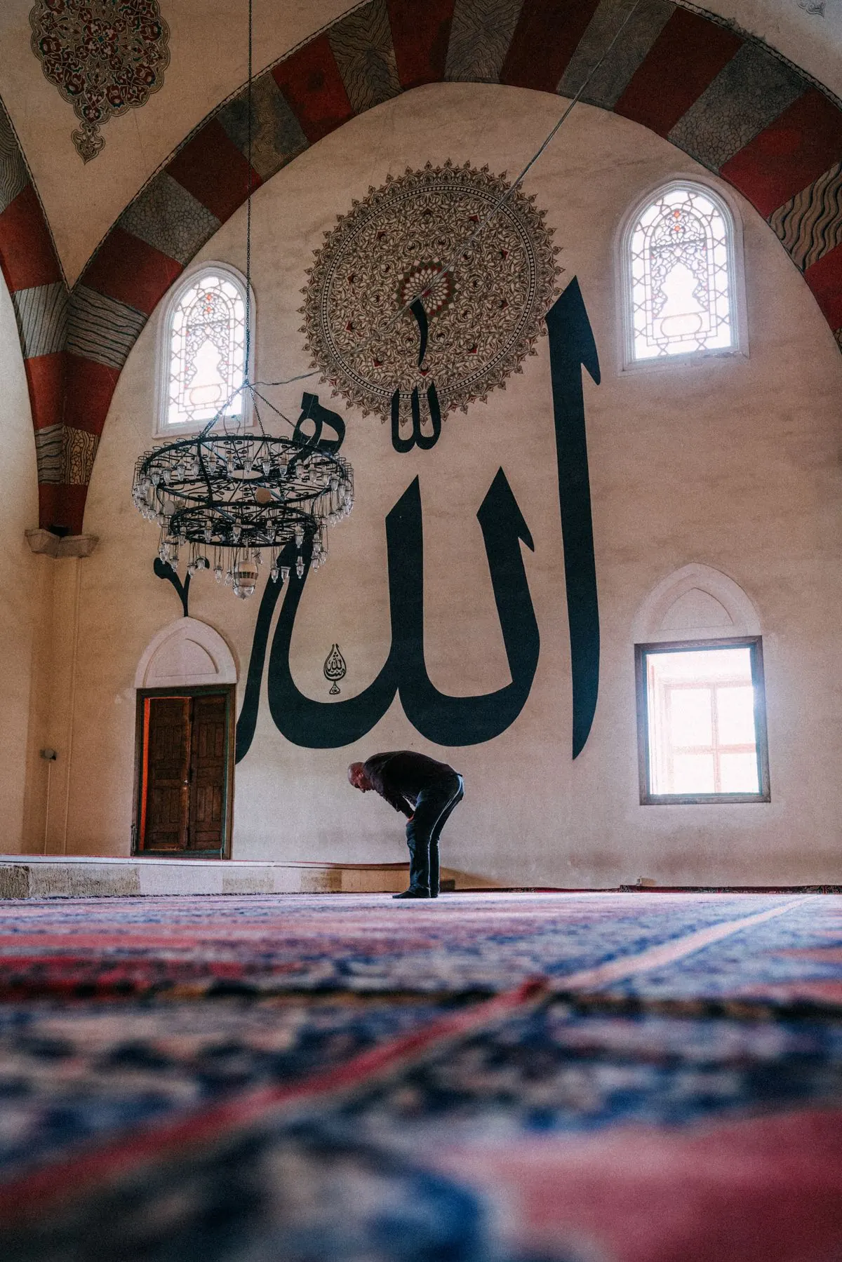 A man bows during Salah inside a mosque.